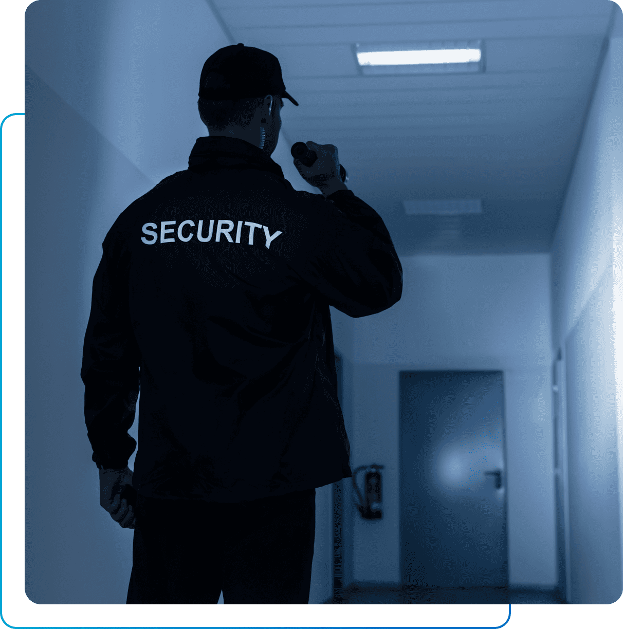 Security guard patrolling a dimly lit hallway.