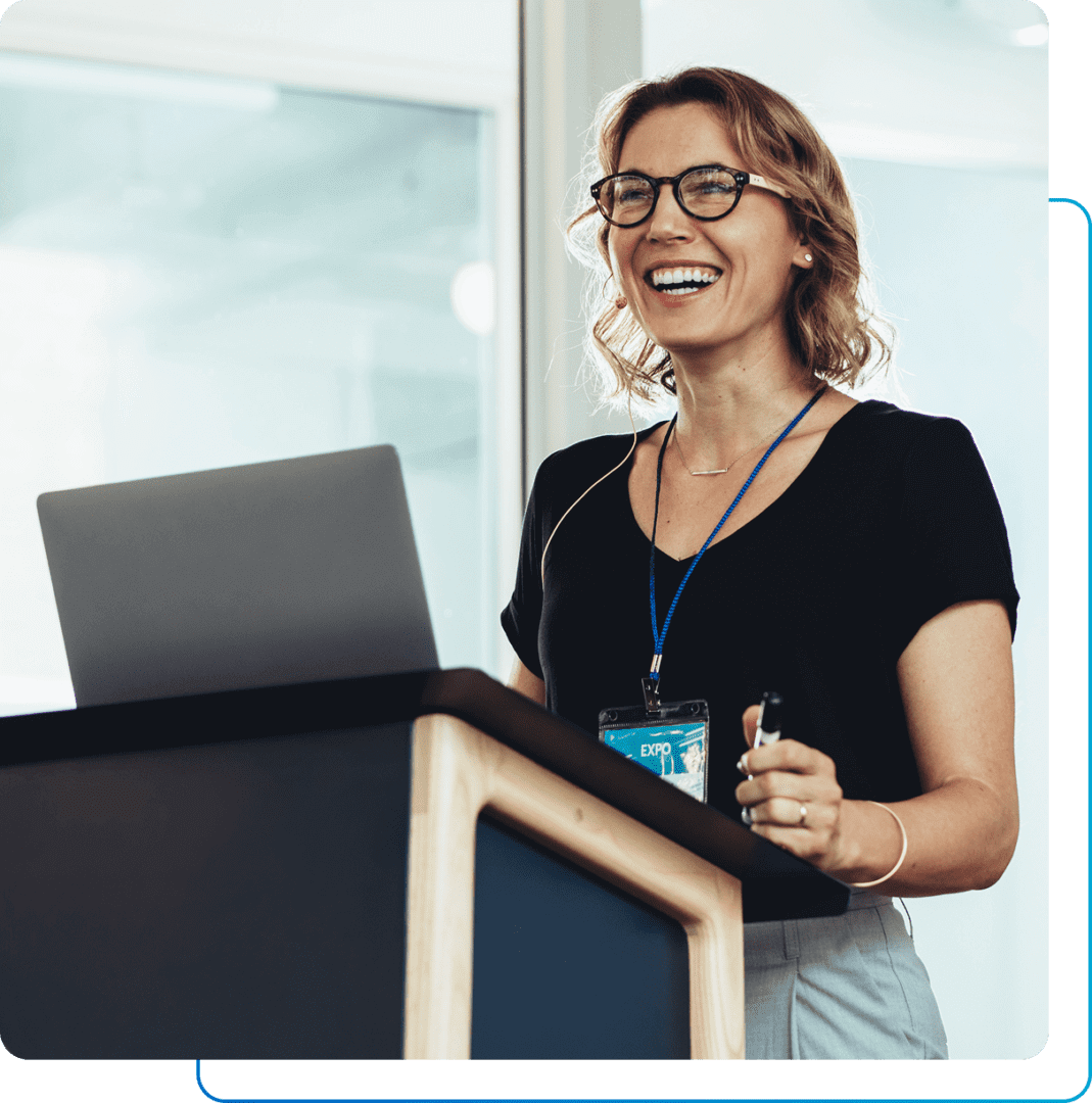 Smiling woman speaking at a podium.